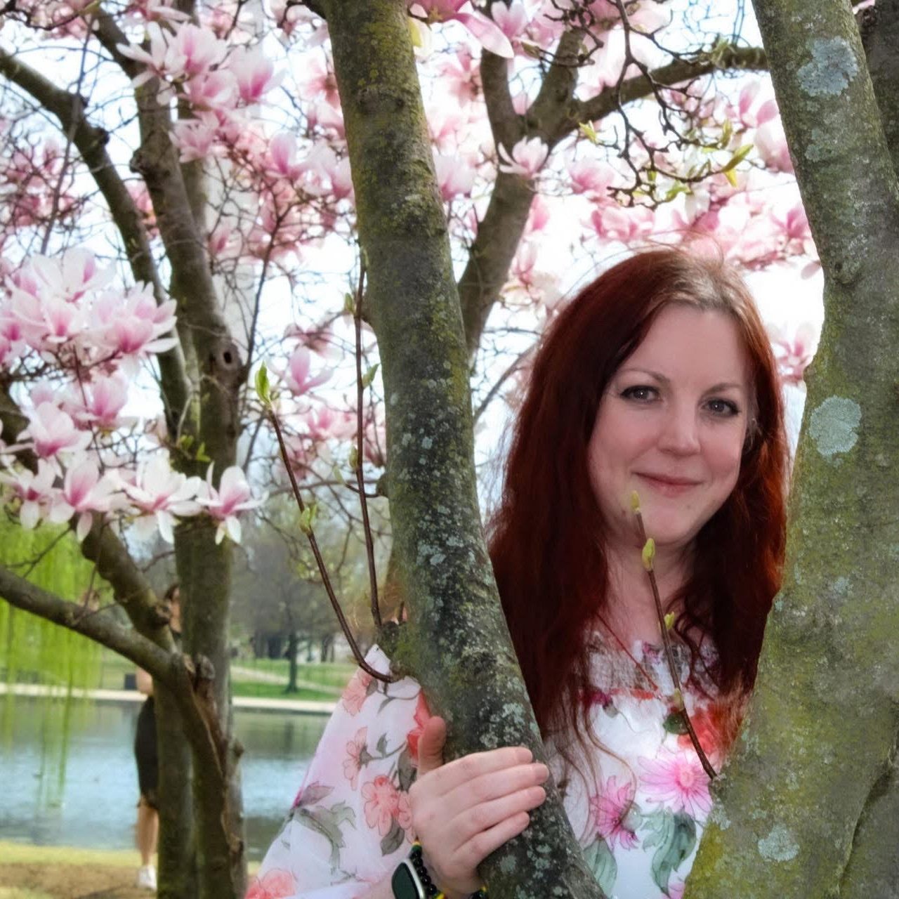 Founder of Recover Arrive Become woman standing behind Japanese Cherry Blossom Tree in Washington D.C.